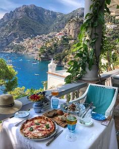 a table with food and drinks on it overlooking the water in amalfa, italy