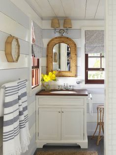 a bathroom with a sink, mirror and towels on the rack in front of it