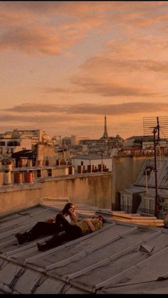 two people sitting on the roof of a building