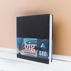 a black book sitting on top of a white shelf