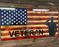 a wooden sign with an american flag and a silhouette of a man saluting the colors of the united states