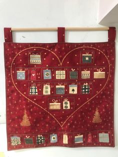 a heart - shaped quilt hanging on a wall with christmas decorations and gifts in it