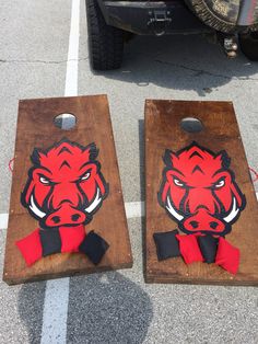 two cornhole game boards with red and black buffalo heads on them sitting in the parking lot