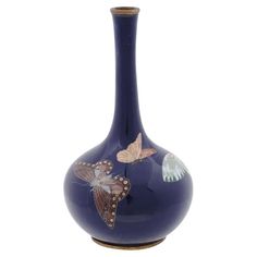 a blue vase with butterflies painted on it