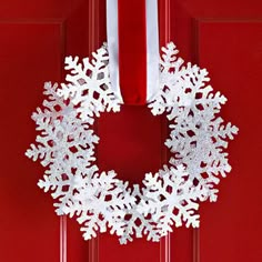 a red door with a white snowflake wreath on it