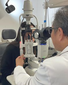 a woman is looking through a pair of glasses at a man in a white lab coat