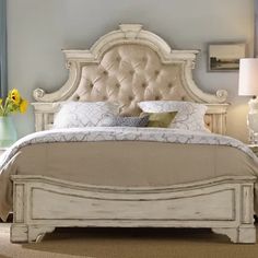 a white bed sitting in a bedroom on top of a carpeted floor next to a window