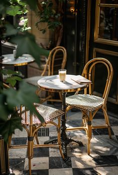 Parisian café scene: wicker chairs, marble table, latte and book in sunlit setting, capturing European coffee culture Cozy Bistro, Parisian Bistro, Parisian Cafe, Parisian Life, French Bistro