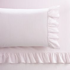 two pillows with ruffled edges on top of each other