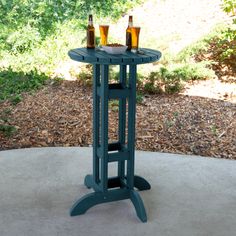 two bottles of beer are sitting on a small table with an open bottle holder in the middle