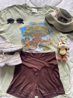 a shirt, shorts, and hat are laid out on a bed with the image of winnie the pooh