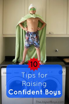 a young boy standing on top of a dryer in front of a green towel