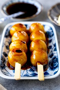 some food is sitting on a blue and white plate with toothpicks in it