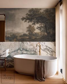 a bathroom with a large painting on the wall and a white bathtub in front of it