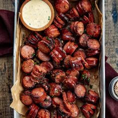 a tray filled with meat and dipping sauce