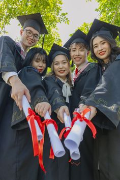 a group of people in graduation gowns holding diplomas