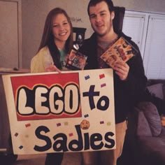 two people standing next to each other holding up a sign that says lego to sadies