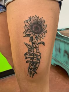 a woman's leg with a sunflower tattoo on it