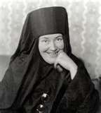 an old black and white photo of a woman in a nun outfit smiling at the camera