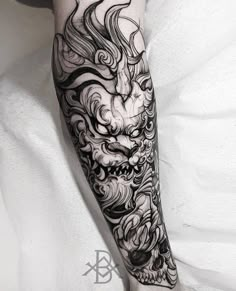 a black and white image of a dragon tattoo on the leg, with waves coming out of it