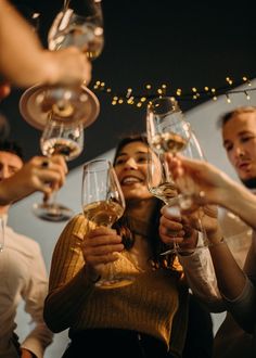 a group of people toasting with wine glasses