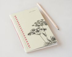 a notepad with a drawing of flowers on it and a pencil next to it