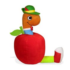 a very cute stuffed animal sitting on top of an apple with a worm sticking out of it's side