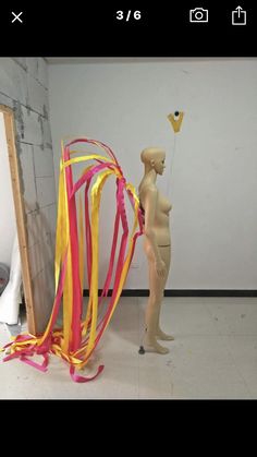 a mannequin holding a kite in the shape of a man