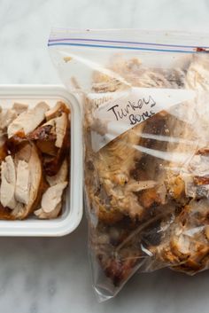 two plastic containers filled with food sitting on top of a white counter next to each other