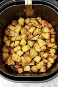 cooked potatoes in an air fryer basket