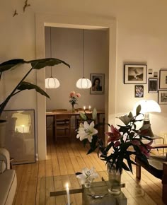 a living room filled with lots of furniture and flowers on top of a wooden floor