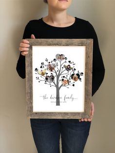 a woman holding up a framed family tree