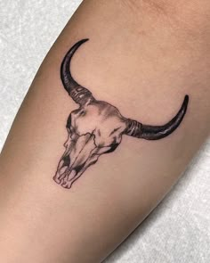 a bull's head tattoo on the right arm is shown in black and white