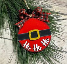 a red ornament hanging from a pine tree with the words ho ho ho on it