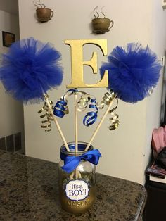 a vase filled with blue pom poms sitting on top of a kitchen counter