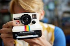 a person taking a photo with a polaroid camera