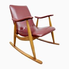 a red leather rocking chair with wooden legs