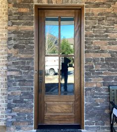 the reflection of a dog in a glass door on a brick building's front porch