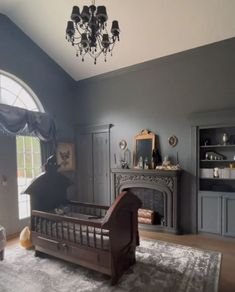 a bedroom with a bed, fireplace and chandelier hanging from the ceiling in front of a window