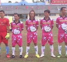 a group of soccer players standing on top of a field next to each other in pink uniforms