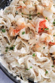 a bowl filled with pasta and shrimp on top of a table