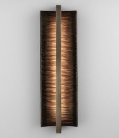 a wall light that is made out of wood and metal with a brown shade on the side