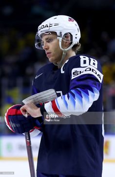 an ice hockey player is holding his helmet and looking at the pucker's mitt