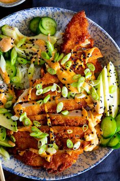 a blue and white bowl filled with food next to chopsticks