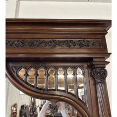 an ornate wooden mirror frame with carvings on it