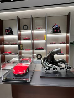 a display case filled with lots of different types of cars and helmets on shelves next to each other