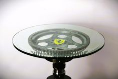 a glass table topped with a metal gear wheel