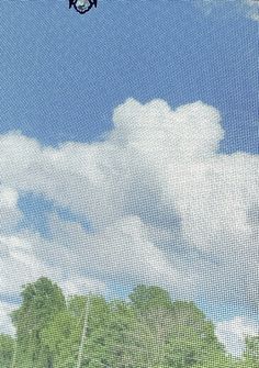 a man flying through the air while riding a skateboard in front of a blue sky with white clouds