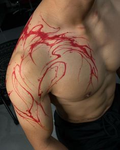 a man with red paint on his arm and chest