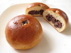 two pastries on a plate with one cut in half